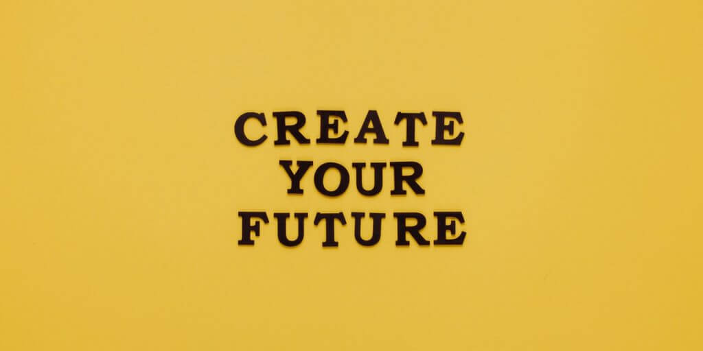 Eine gelbe Fläche mit dem Text "CREATE YOUR FUTURE" – hoffentlich kommst du mithilfe unserer Anleitung zur Visionsreise zu deinem Vision-Statement!