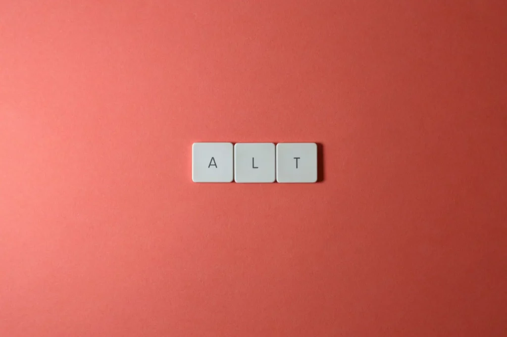 Drei Scrabble-Plättchen, die das Wort ALT formen